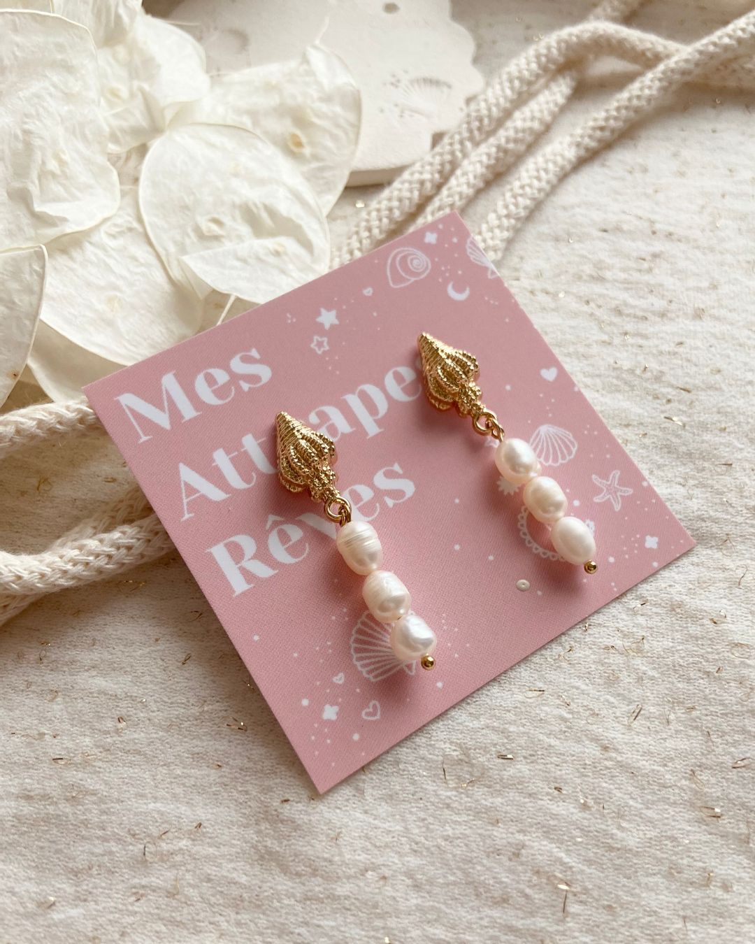 Boucles d'oreilles Mira composées d'une jolie puce en forme de coquillage doré et d'un pendentif de trois perles d'eau douces arrondies blanc nacrée réalisées à la main par la créatrice Johanne de Mes attrapes rêvesBoucles d'oreilles Mira composées d'une jolie puce en forme de coquillage doré et d'un pendentif de trois perles d'eau douces arrondies blanc nacrée réalisées à la main par la créatrice Johanne de Mes attrapes rêves