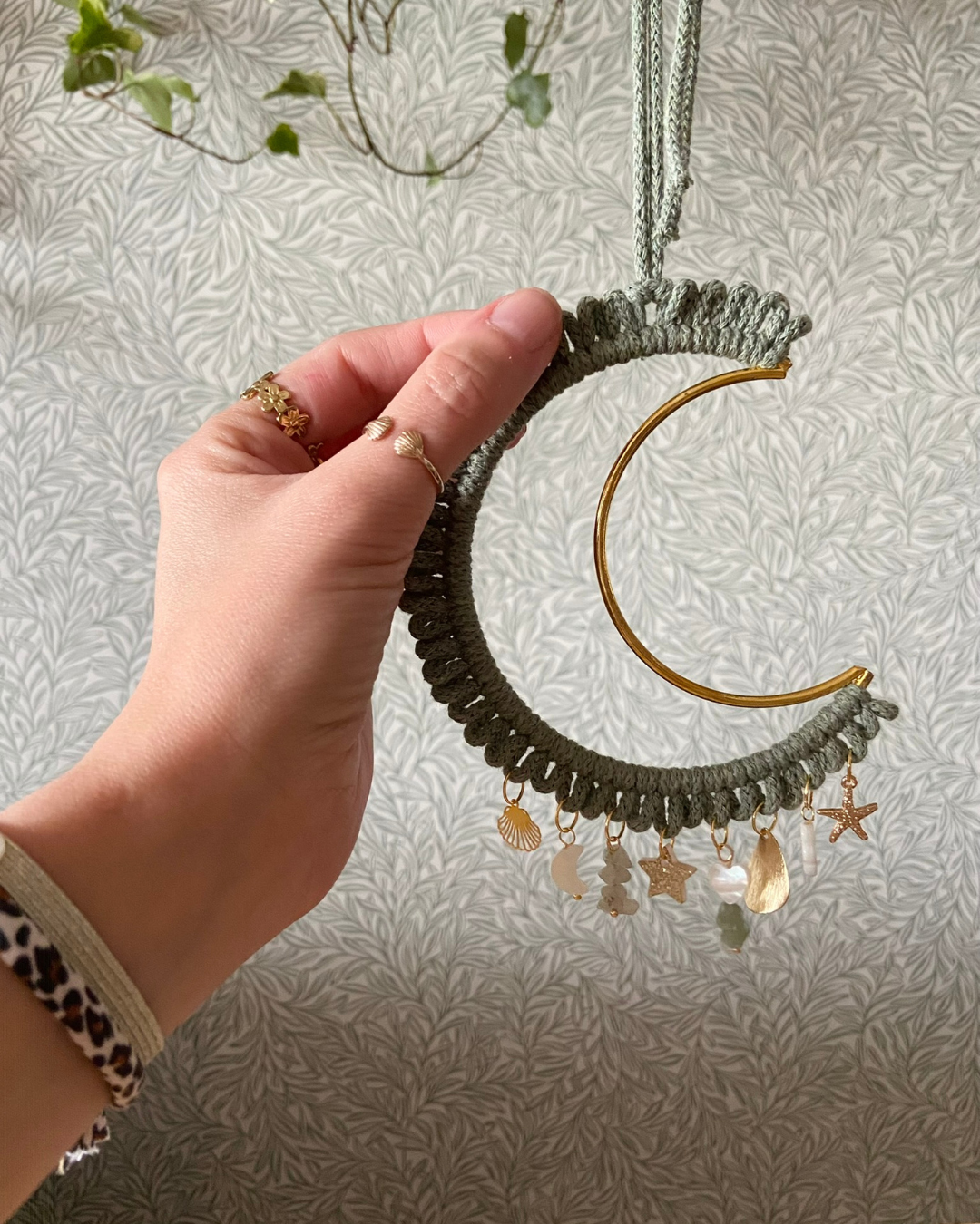 Grande Lune gri-gri vert kaki - Bohème - Lune dorée en macramé et pampilles protectrices ✨🌙
Ajoutez une touche magique et artisanale à votre intérieur avec cette suspension attrape-rêves en forme de lune, entièrement fait main. Conçu avec un crochet délicat en coton, il est orné d’un croissant de lune doré ainsi que de magnifiques breloques protectrices symbolisant l’amour et l’énergie positive.