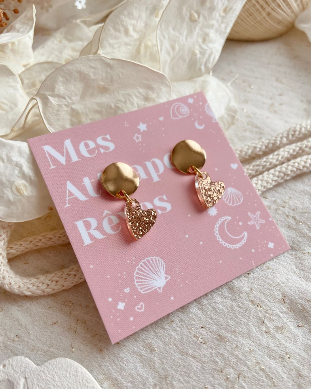 boucles d’oreilles cœur doré pailleté. Composées d’un pendentif cœur scintillant et d’un fermoir doré, elles allient élégance et originalité pour sublimer toutes vos tenues.