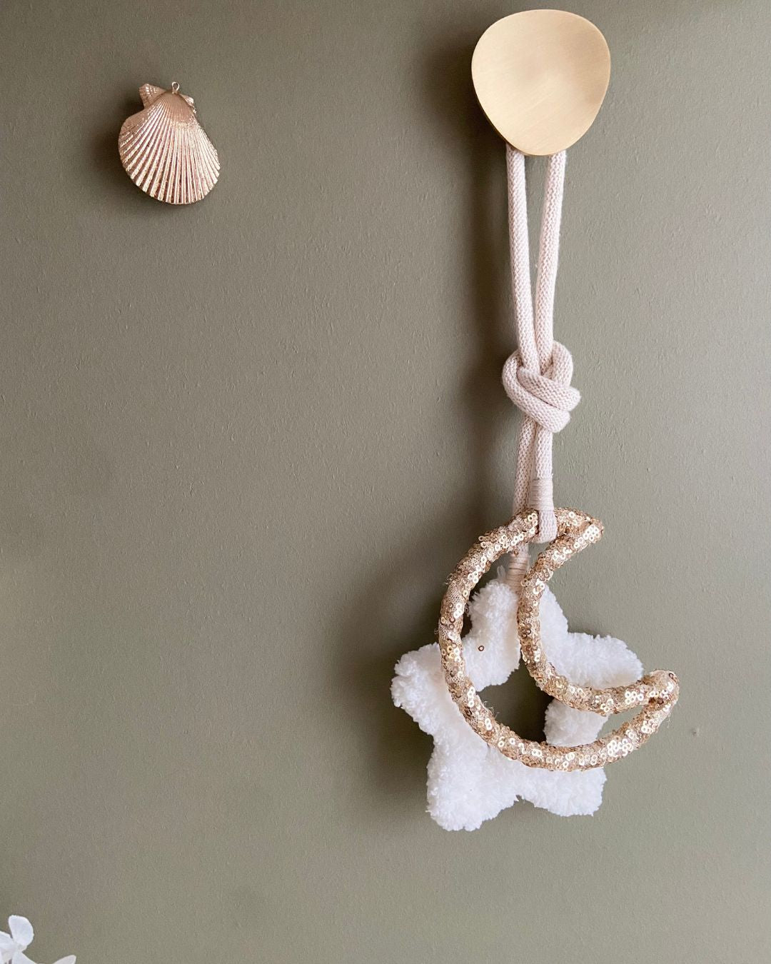 Présentation de notre suspension avec étoile moumoute blanche et lune avec sequins dorés, ici nouée et accrochée au mur sur une patère – une création élégante et poétique signée Mes Attrapes Rêves.